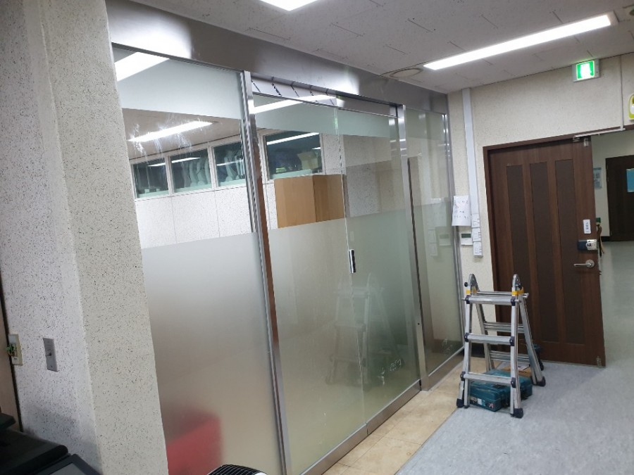 사무실 내부 유리 파티션과 함께 시공된 슬라이딩 유리문