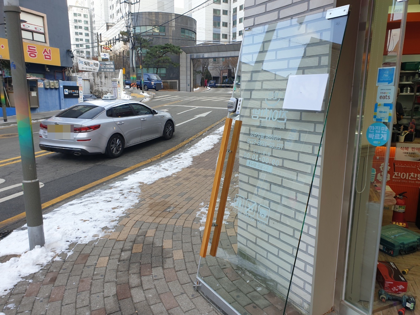 강화도어 힌지 교체를 위해 유리문을 조심스럽게 탈거하는 과정