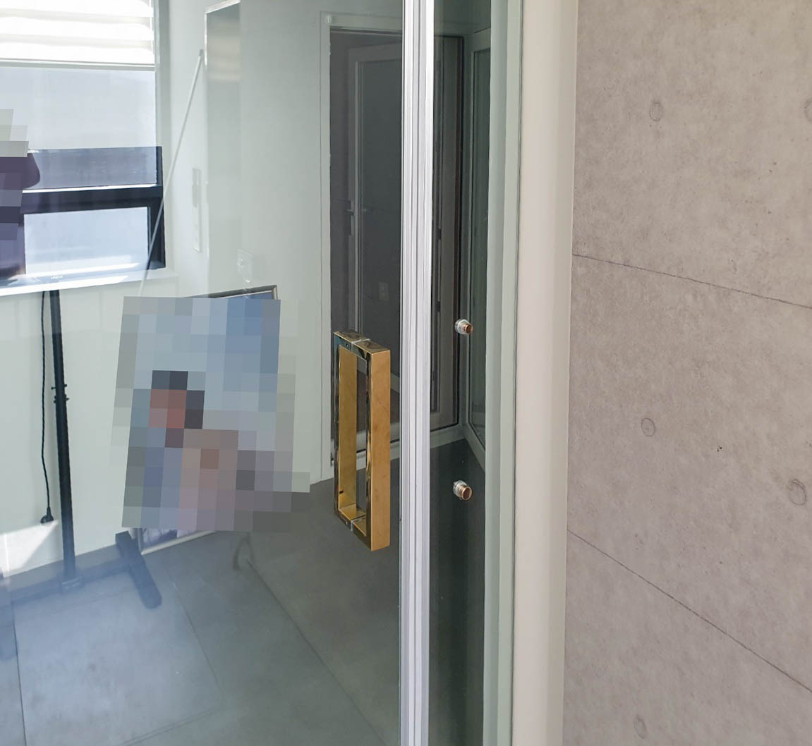 마포구 동교동 강화유리문 교체 손보호대 시공 후기 강화도어 틈새에 정확하게 새 손보호대를 부착하는 모습