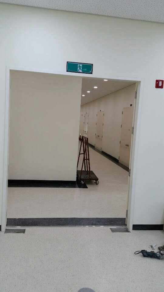 새 유리문 너머로 보이는 복도 풍경