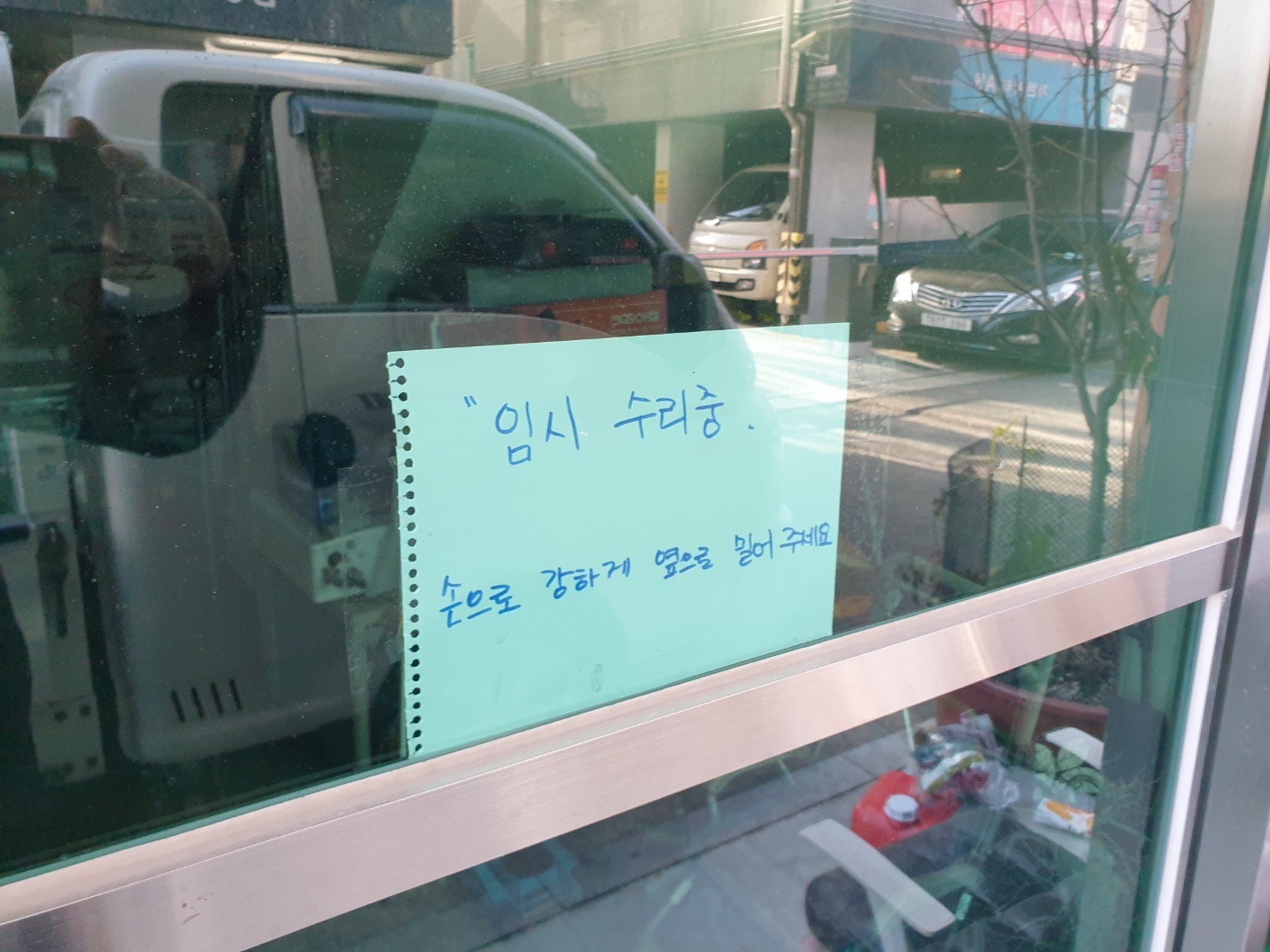 자동문 유리에 붙어있는 임시 수리중 안내문